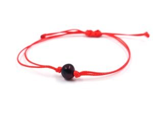 Red thread string bracelet with amber