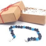 Adjustable unpolished black amber bracelet with blue cats eye